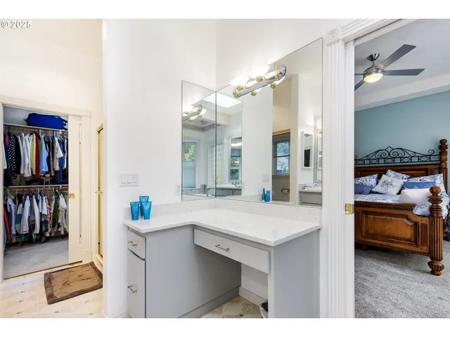 a spacious bathroom with a sink a large mirror a bathtub and next to a window