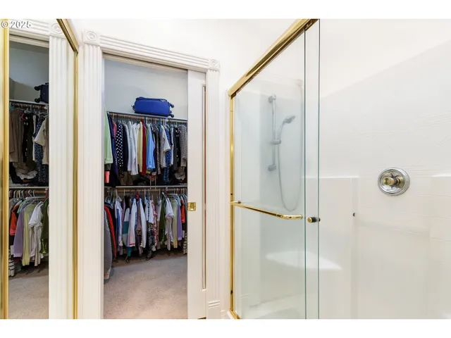 a view of walk in closet with clothes and shoes