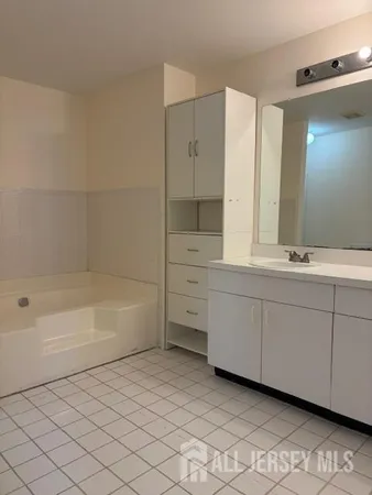 a bathroom with a bathtub sink and mirror