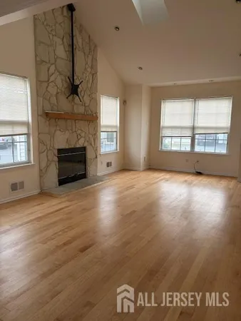 a view of empty room with a fireplace and wooden floor