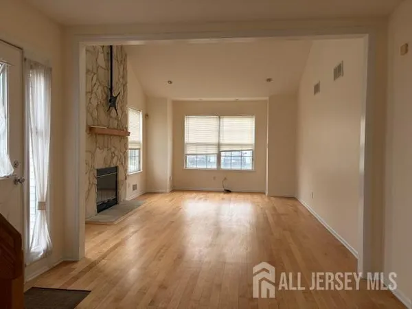 a view of an empty room with a window and a fireplace