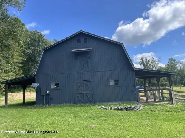 an empty room with wooden floor closet and windows