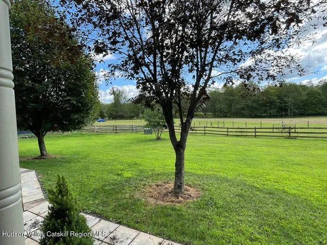 a view of a bedroom with wooden floor and windows