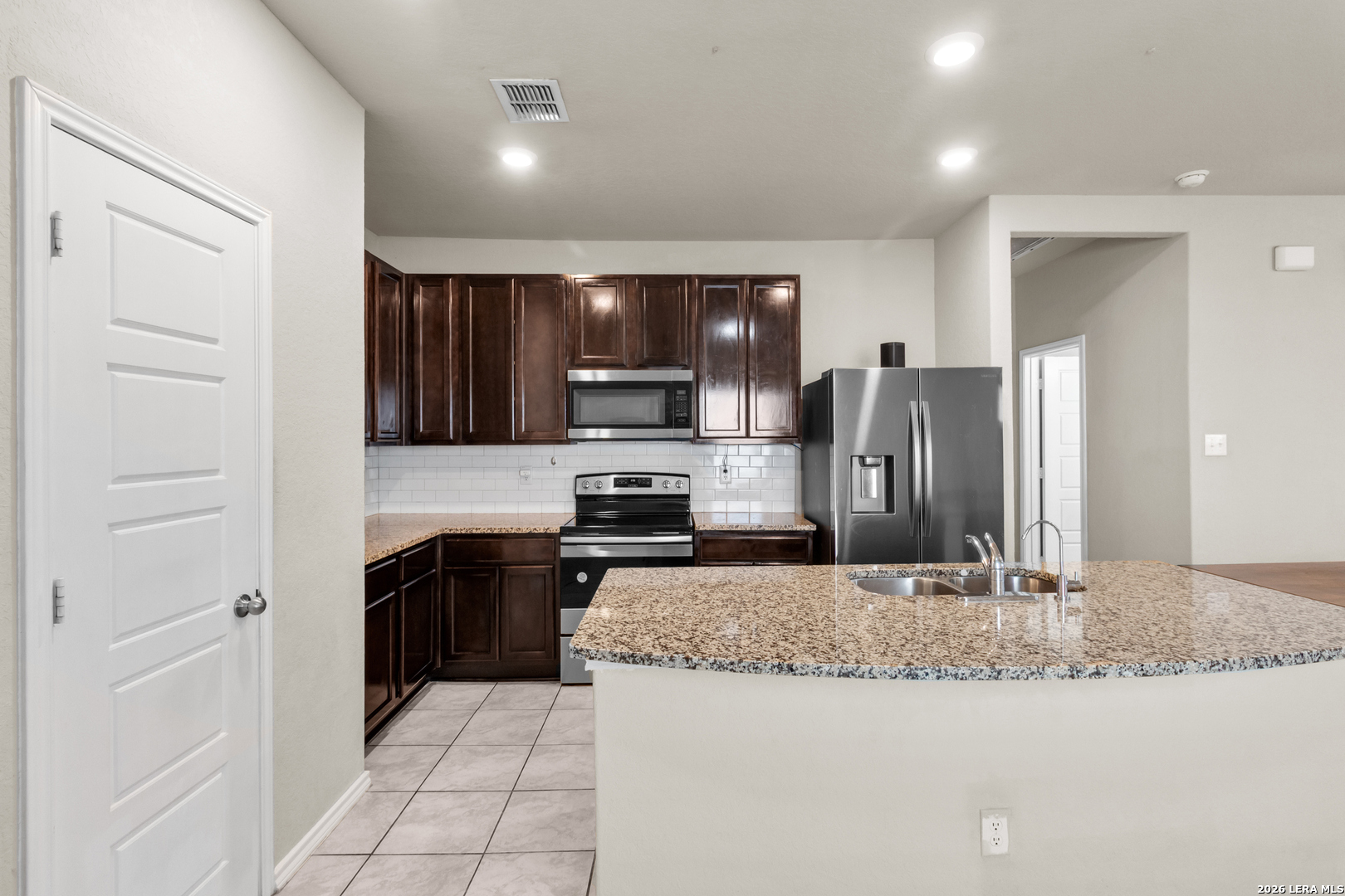 5919 Poolside Park Converse, TX 78109 - Photo 5 of 25 a kitchen with stainless steel appliances granite countertop a refrigerator and a sink