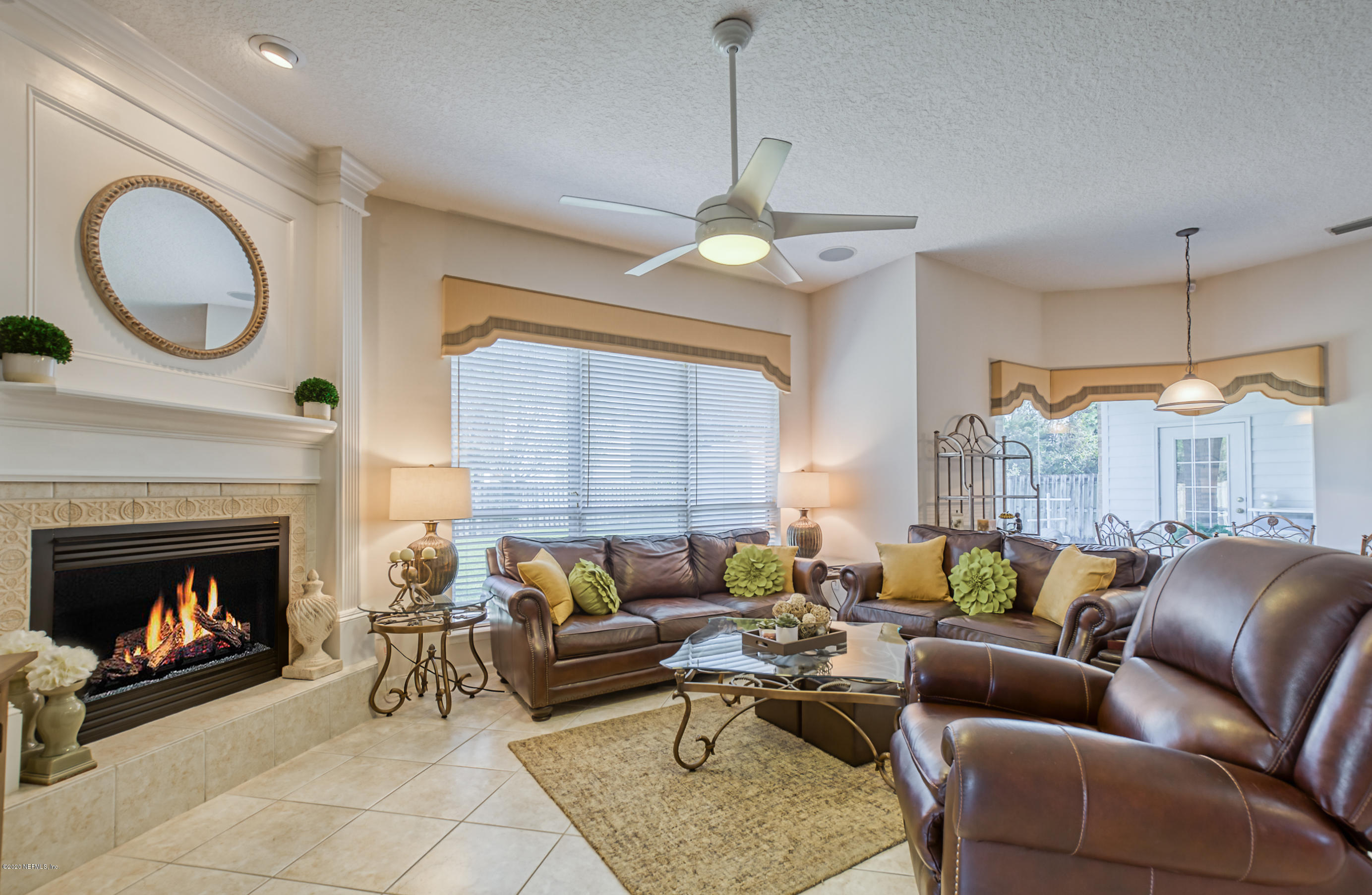 12003 Spring Ridge Drive Jacksonville, FL 32258 - Photo 8 of 33 a living room with furniture a fireplace and a chandelier