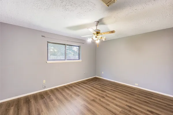 a view of a room with wooden floor and chandelier fan
