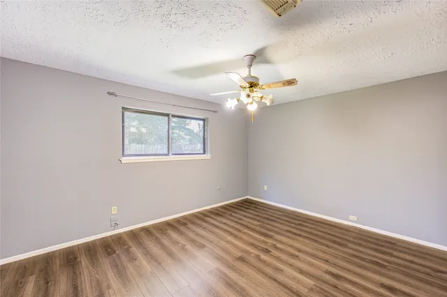 a view of a room with wooden floor and chandelier fan