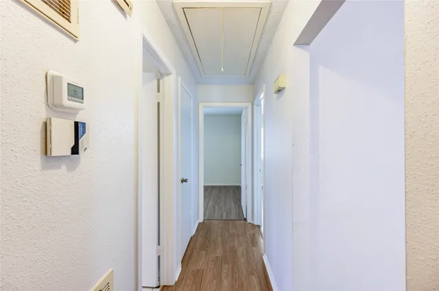 a view of a hallway with wooden floor and entryway