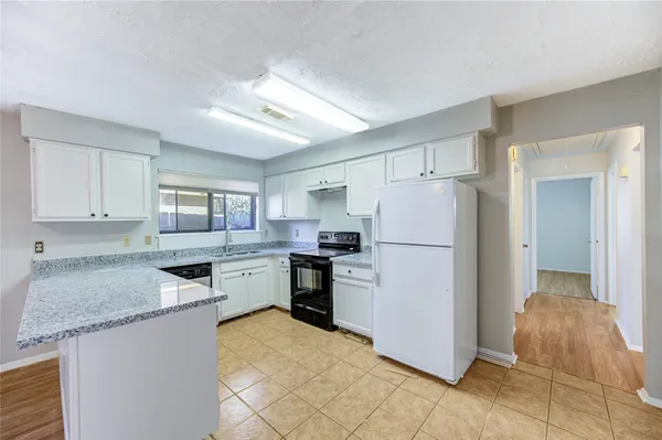 a kitchen with granite countertop a refrigerator and a sink