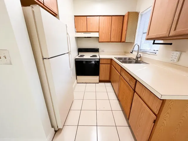a kitchen with a sink a refrigerator and a window