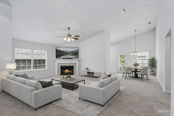 a living room with furniture a fireplace and a chandelier