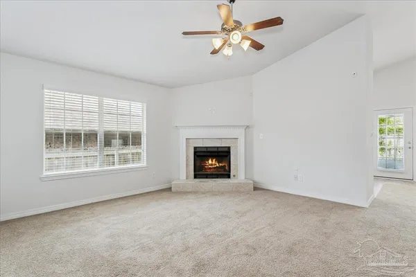 an empty room with windows and fireplace