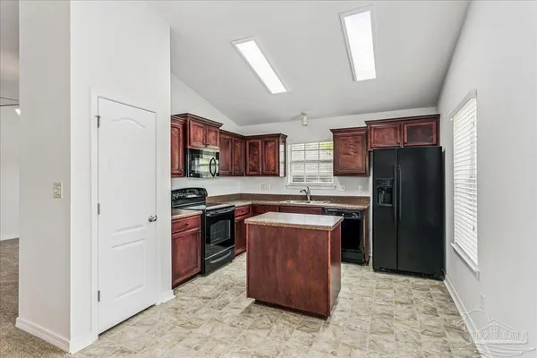 a kitchen with stainless steel appliances granite countertop a refrigerator stove and sink