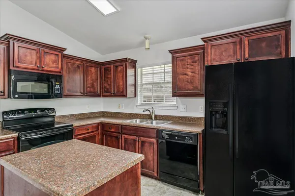 a kitchen with a stove a sink and a microwave
