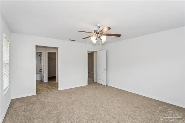 a view of an empty room with a ceiling fan