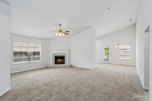 an empty room with windows and fireplace