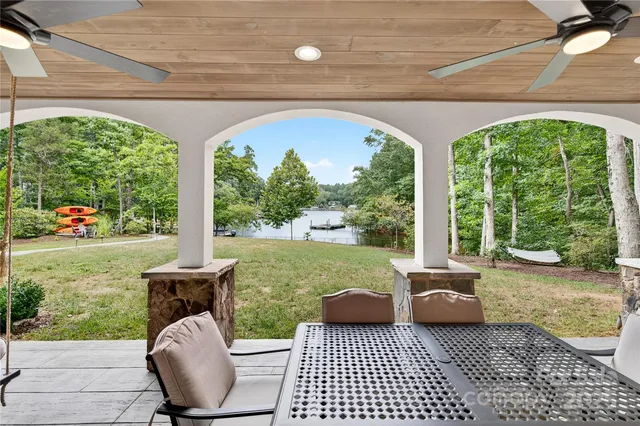 a patio with table and chairs and potted plants