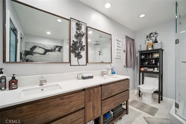a bathroom with a double vanity sink mirror and toilet