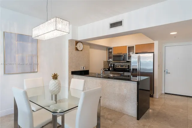 a kitchen with stainless steel appliances granite countertop a sink refrigerator and microwave