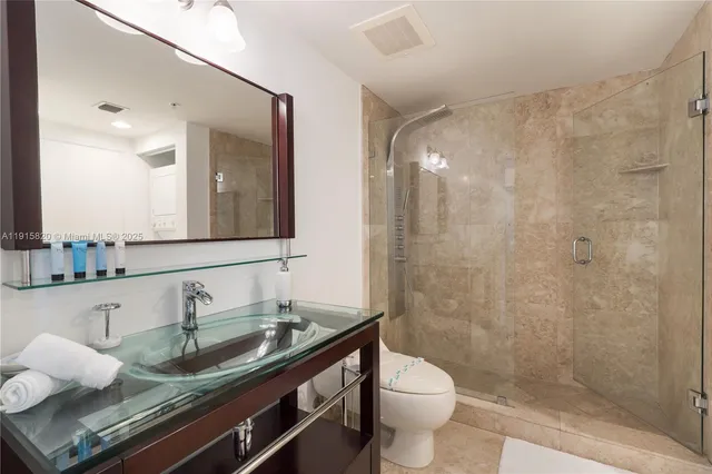 a bathroom with a granite countertop sink a toilet and a mirror
