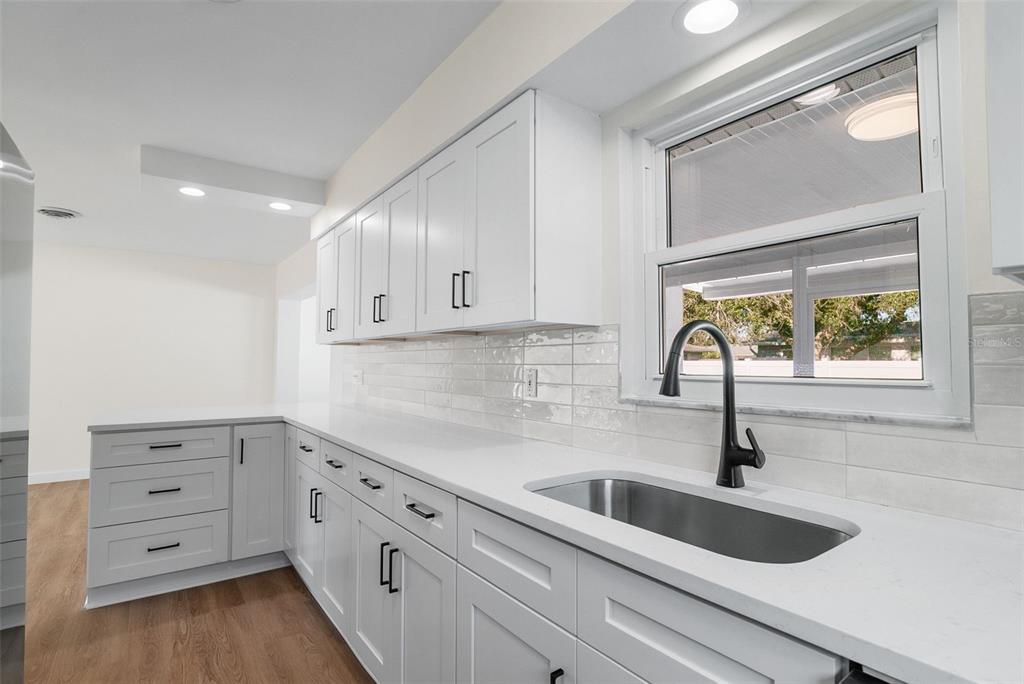 354 Burke Road Venice, FL 34293 - Photo 13 of 34 a kitchen with granite countertop white cabinets and sink