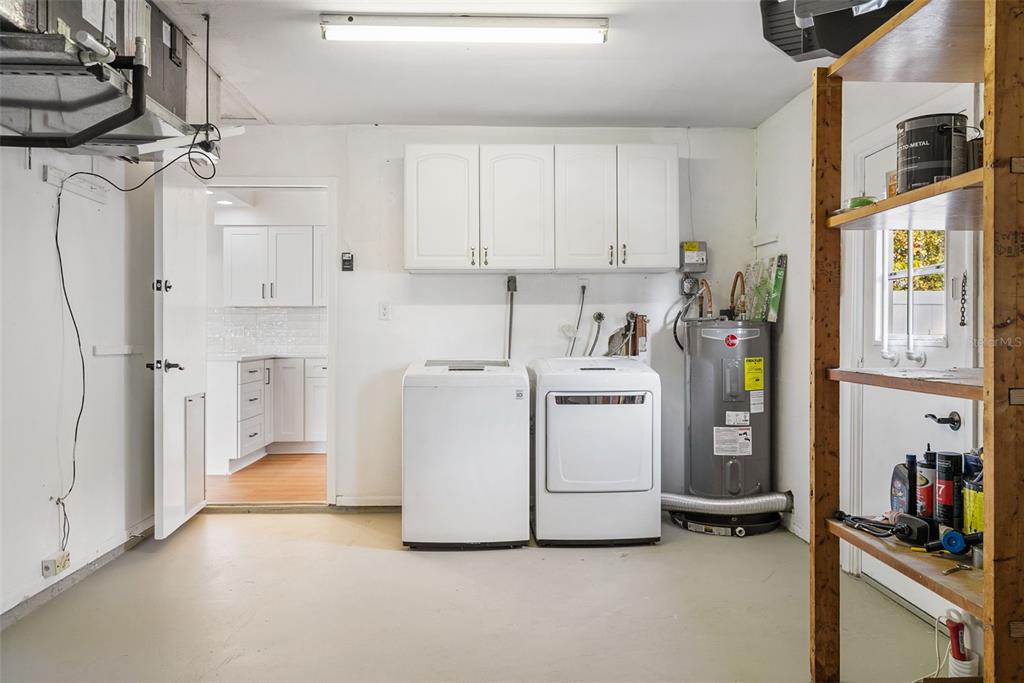 354 Burke Road Venice, FL 34293 - Photo 17 of 34 a utility room with cabinets dryer and washer
