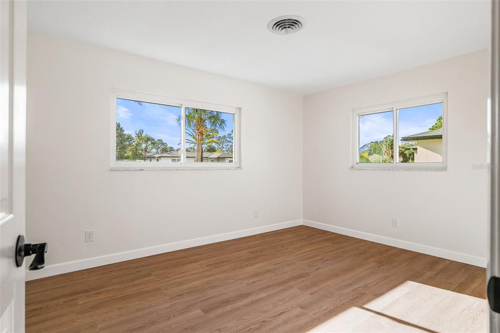 354 Burke Road Venice, FL 34293 - Photo 21 of 34 a view of an empty room with wooden floor and a window