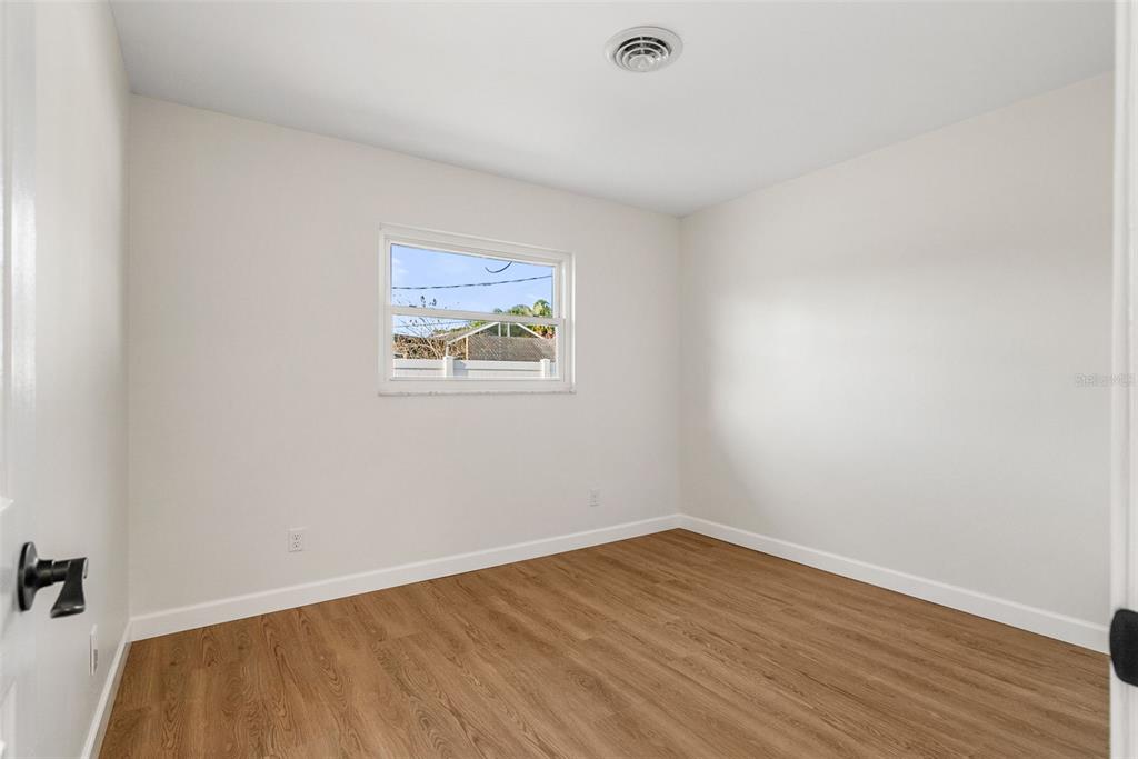 354 Burke Road Venice, FL 34293 - Photo 23 of 34 a view of an empty room with wooden floor and a window