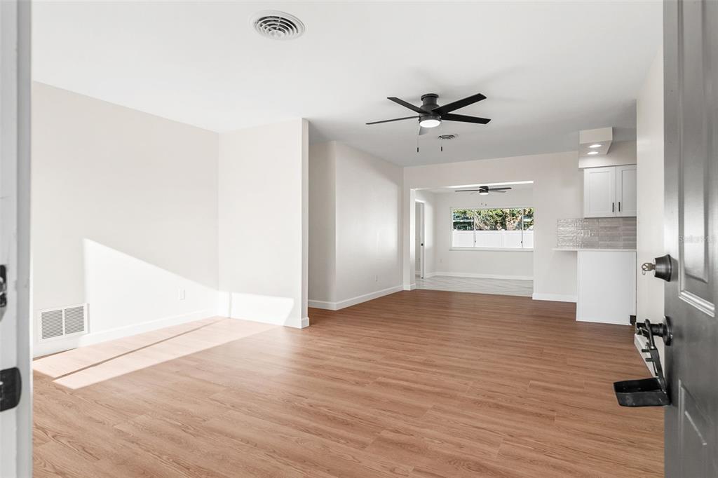 354 Burke Road Venice, FL 34293 - Photo 5 of 34 a view of an empty room with a window and wooden floor