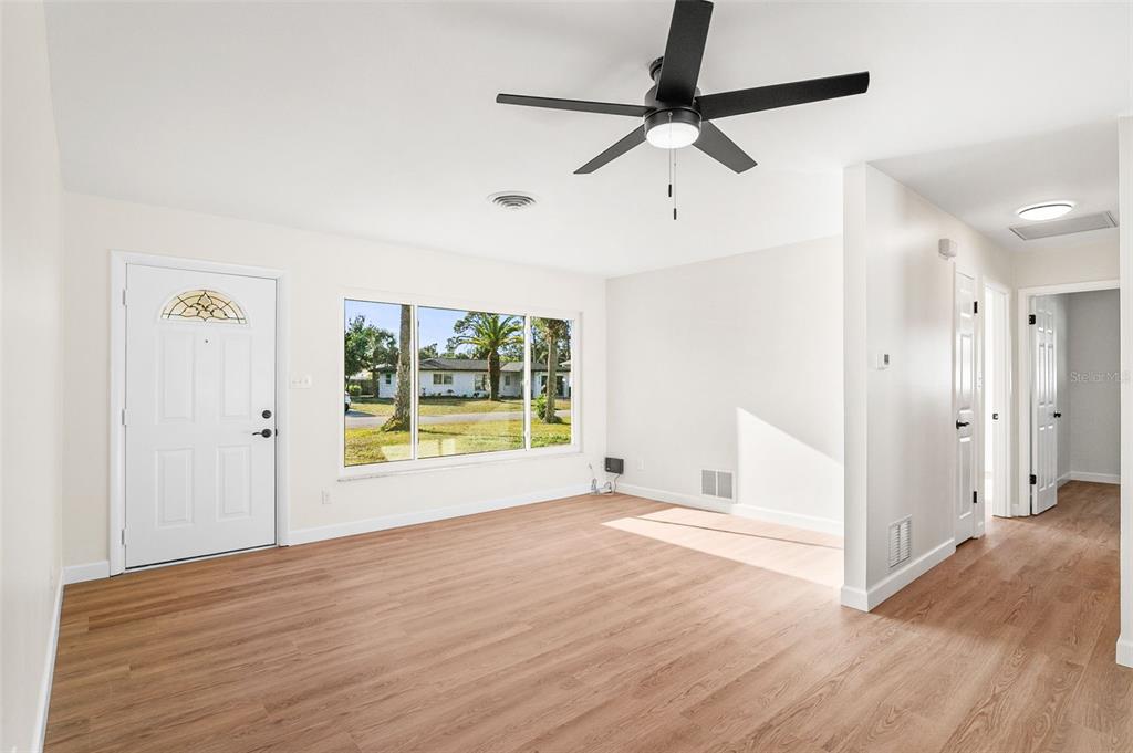 354 Burke Road Venice, FL 34293 - Photo 8 of 34 a view of empty room with wooden floor and fan