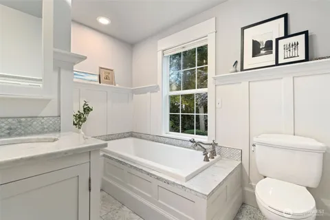 a bathroom with a granite countertop sink a mirror and a shower
