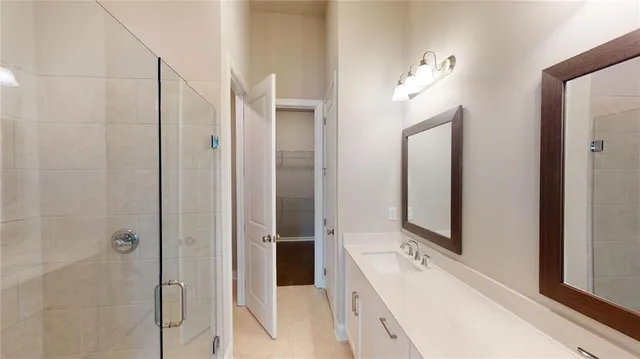 a en suite bathroom with a double vanity sink a mirror and a shower