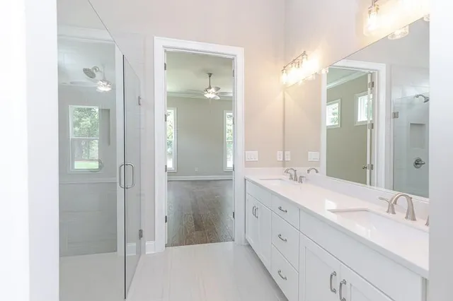 a spacious bathroom with a double vanity sink mirror and shower