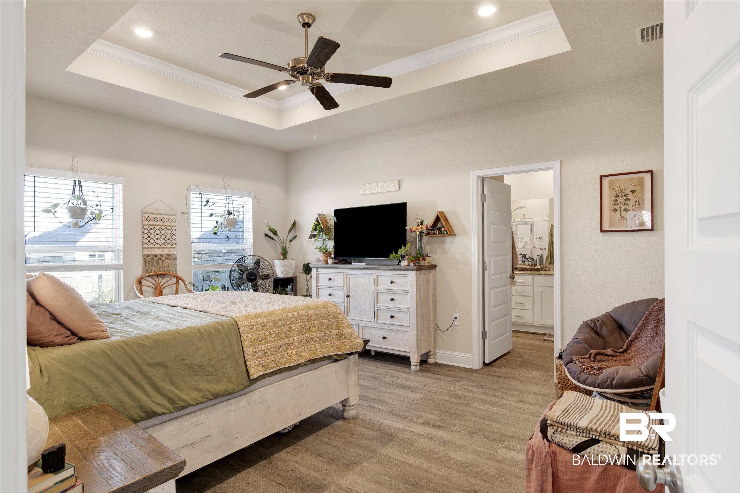 9622 Volterra Avenue Daphne, AL 36526 - Photo 16 of 31 Bedroom featuring ceiling fan, light hardwood / wood-style floors, ensuite bath, and a tray ceiling