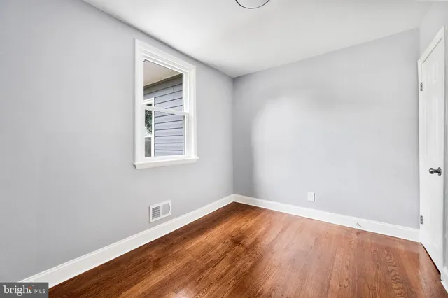 a view of a room with wooden floor and a window
