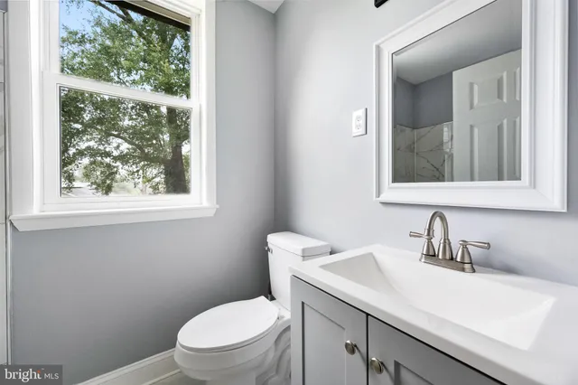 a bathroom with a sink a toilet and a window