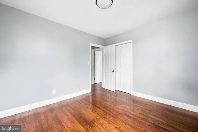 a view of a room with wooden floor and white walls