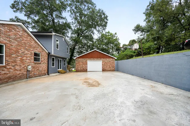 a view of a house with a yard and large tree