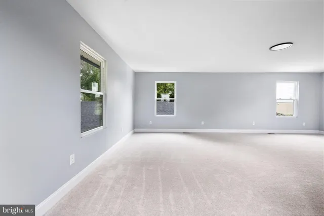 an empty room with windows and closet