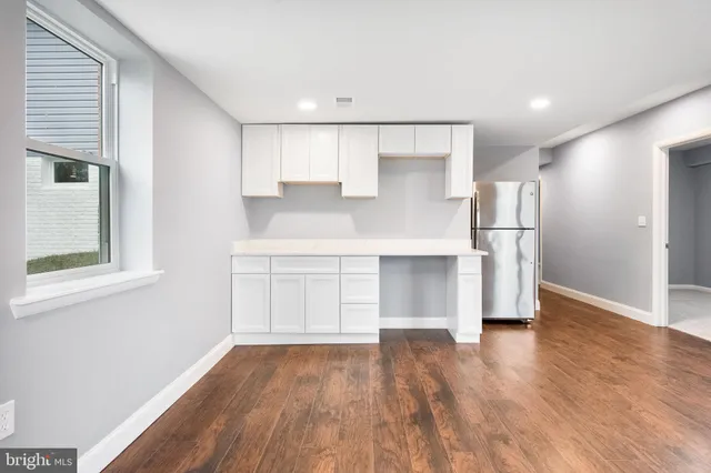 a view of kitchen with wooden floor and electronic appliances