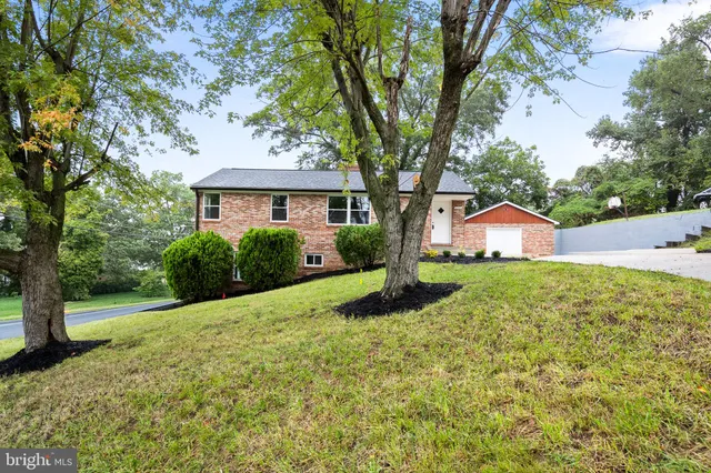 a front view of a house with a yard and trees