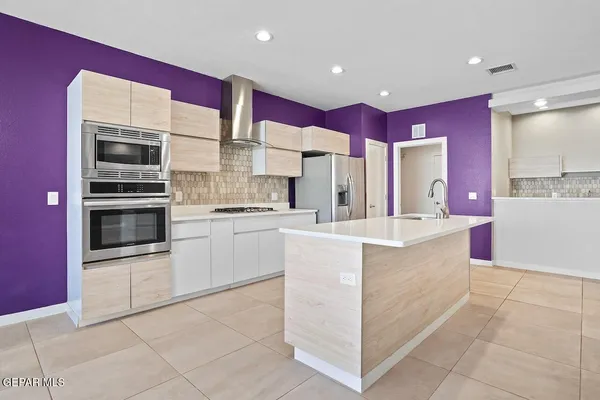 a view of an empty room with wooden floor and cabinets