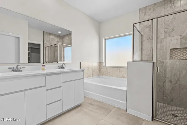 a bathroom with a tub sink and mirror