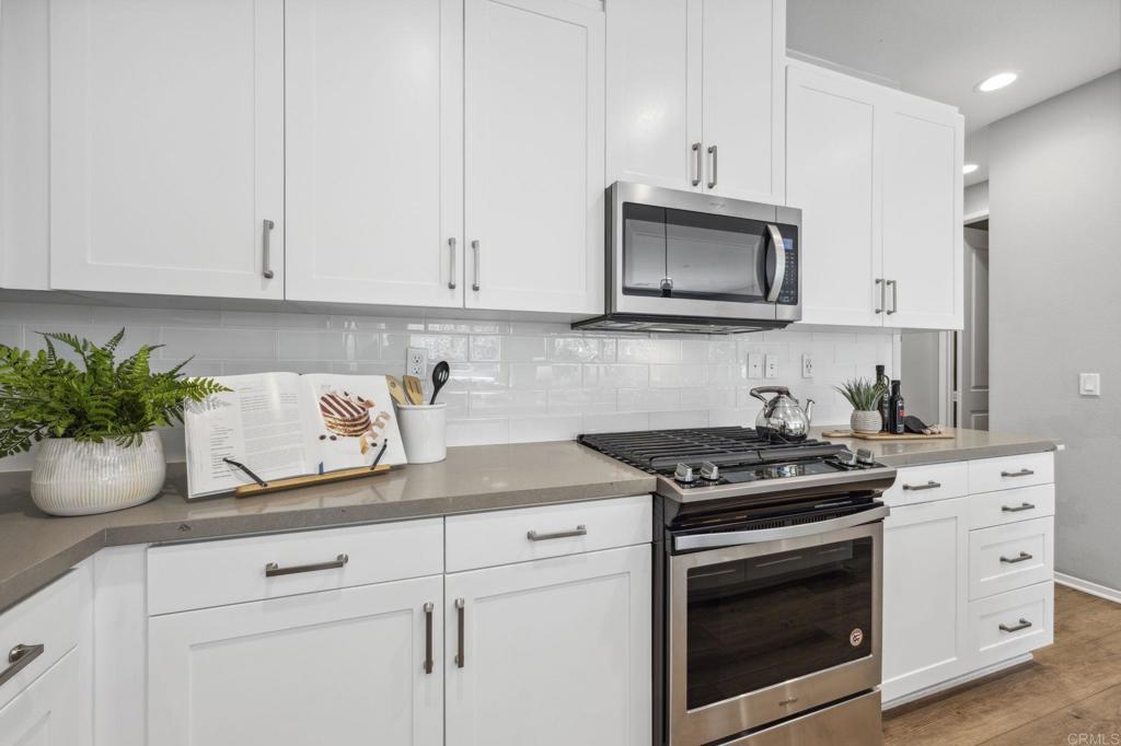 1167 Via Lucero Oceanside, CA 92056 - Photo 16 of 54 a kitchen with white cabinets and appliances