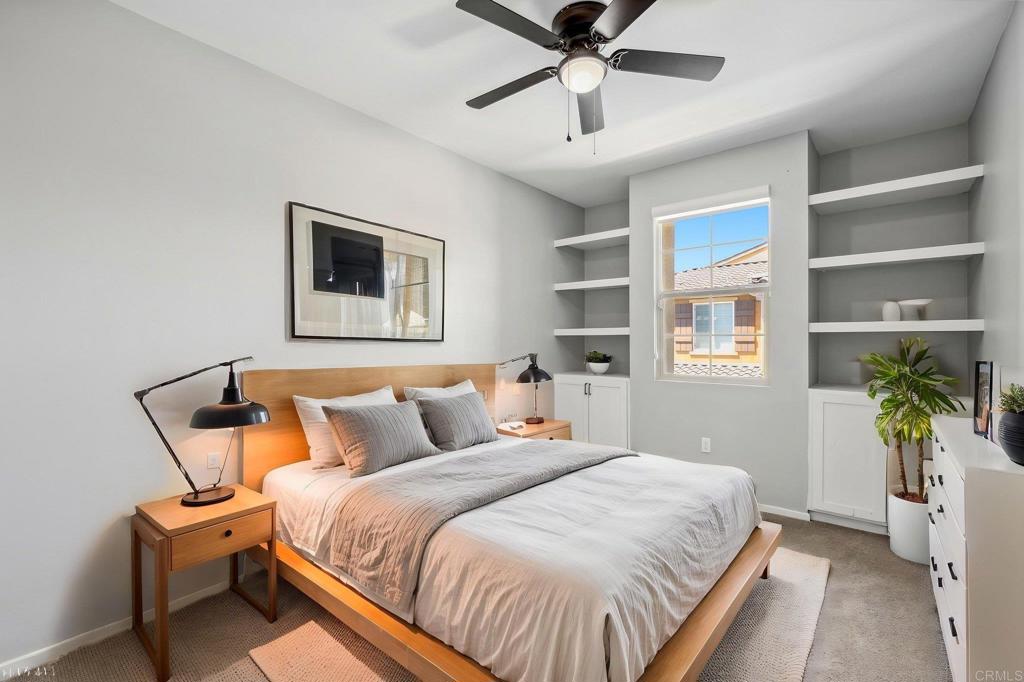 1167 Via Lucero Oceanside, CA 92056 - Photo 25 of 54 a bedroom with a bed and a chandelier