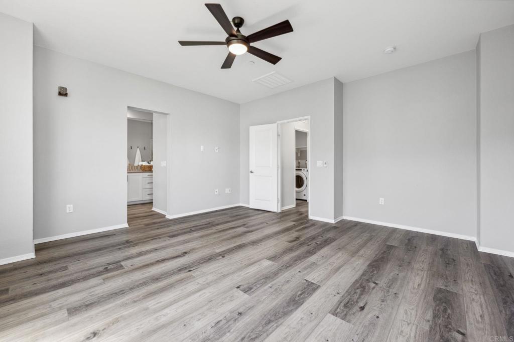 1167 Via Lucero Oceanside, CA 92056 - Photo 31 of 54 an empty room with wooden floor and a ceiling fan