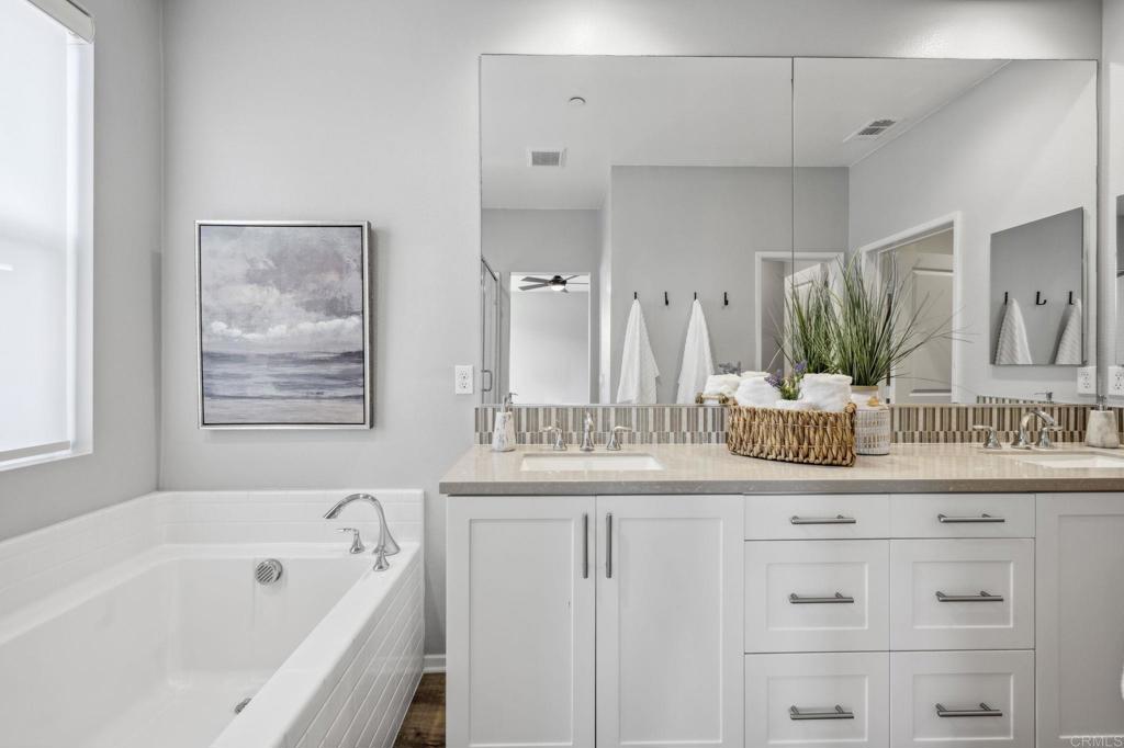 1167 Via Lucero Oceanside, CA 92056 - Photo 32 of 54 a bathroom with a granite countertop sink mirror and a bathtub