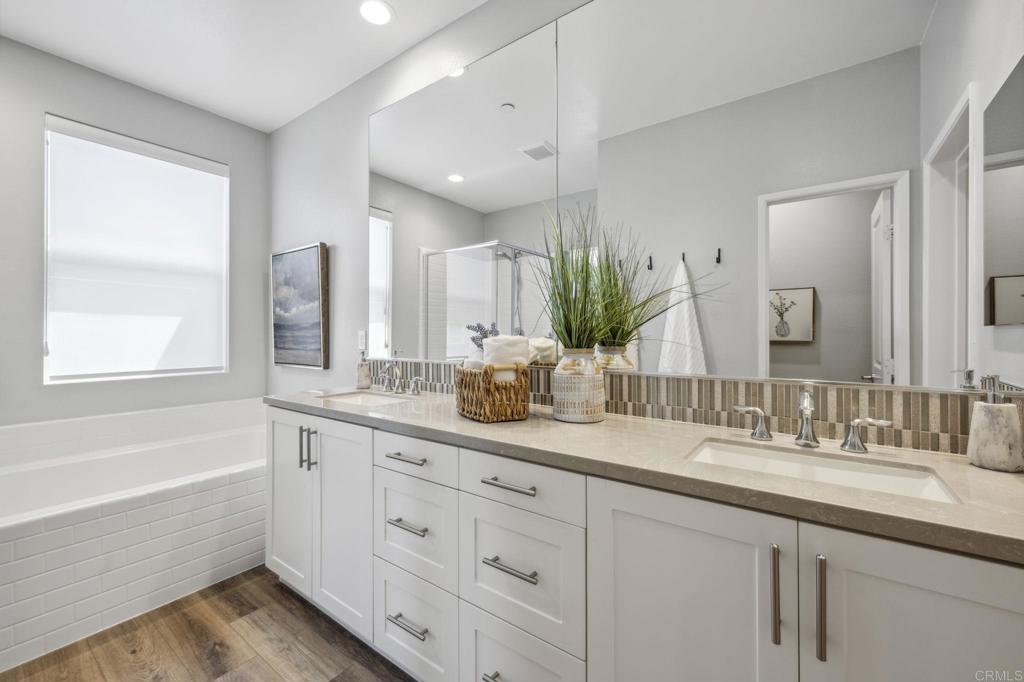 1167 Via Lucero Oceanside, CA 92056 - Photo 34 of 54 a bathroom with a granite countertop double vanity sink a mirror and a bathtub