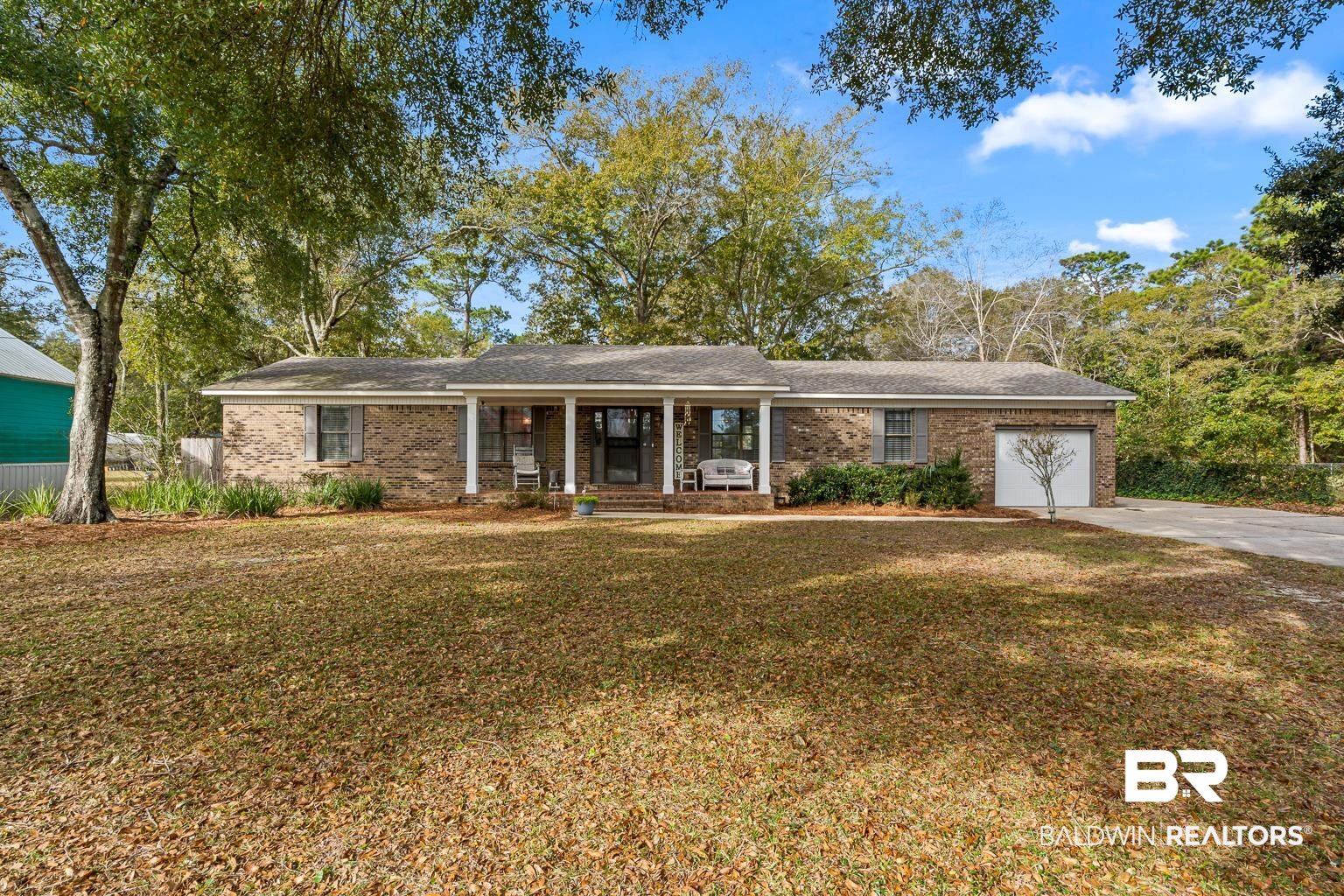 6801 Piney Woods Road Foley, AL 36535 - Photo 1 of 74 Ranch-style home featuring a porch, a front yard, an attached garage, and brick siding