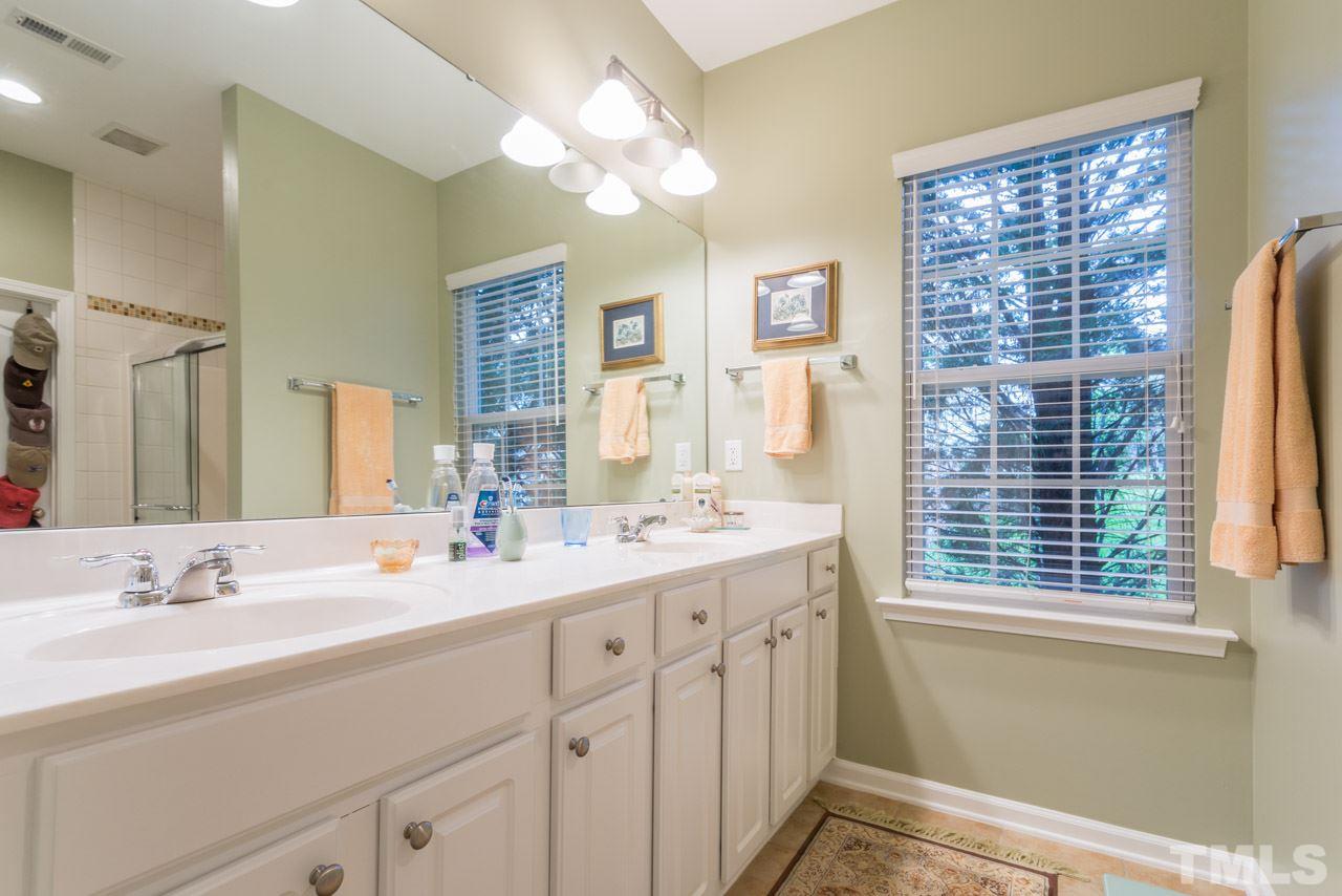 3406 Cathedral Bell Road Raleigh, NC 27614 - Photo 14 of 25 a bathroom with a double vanity sink a large mirror and a bathtub
